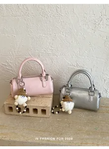Detail showing pink and silver textured PU leather barrel bags with plush dwarf charms