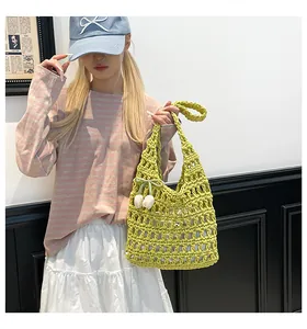 Close-up of a handmade yellow hollow woven tote bag with a white tulip flower pendant
