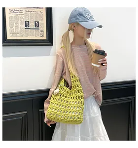 Detail of lime green crochet tote bag with white floral accents and open mesh pattern