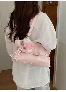 Pink minimalist tote bag with retro belt buckle detail and plush bear charm on model