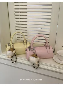 Detail view of mini cylinder boston bags with plush charms and beaded chain straps