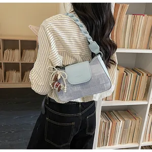 Close-up of retro square crossbody bag with pony charm and woven strap in a library