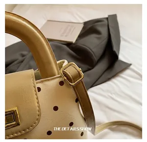 Detailaufnahme des verstellbaren Schultergurts mit goldener Metallschnalle am gepunkteten Bag