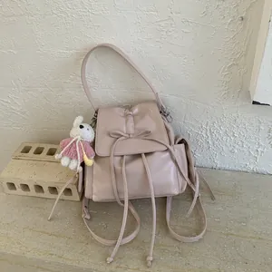 Pink faux leather backpack with bow drawstring and a cute white rabbit pendant