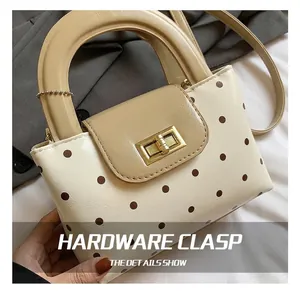 Nahaufnahme des goldenen Metallverschlusses an der gepunkteten Vintage-Handtasche