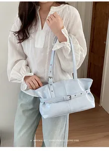 Light blue glossy tote bag with buckle detail and retro vibe shown on a model