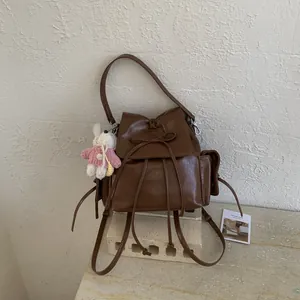Dark brown PU leather backpack with bow detail and cute white bunny plush pendant