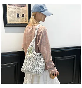 Detailed shot of white hand-woven crochet tote bag with a tulip floral charm accessory