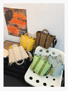 Detail showing colorful canvas bucket bags in yellow, brown, blue and green colors