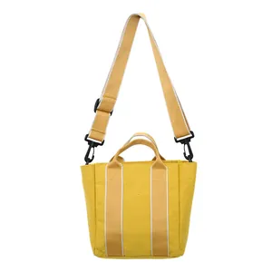 Bright yellow canvas bucket bag featuring contrasting straps and adjustable shoulder strap
