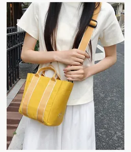 Detail of yellow canvas bucket bag featuring sun embroidery and adjustable wide strap