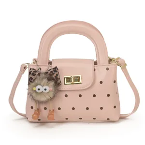 Rosa gepunktete Handtasche mit Goldschloss und Leoparden-Anhänger auf weißem Grund