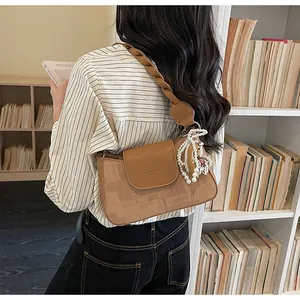 Close-up of vintage brown textured bag with pearl bear charm in a library setting