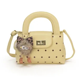 Detailansicht der gelben gepunkteten Handtasche mit Goldschloss und Eulen-Anhänger