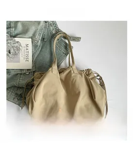 Dettaglio borsa tote kaki con coulisse, manici cilindrici e tracolla regolabile