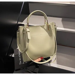 Dettaglio della borsa a secchiello verde pistacchio in pelle liscia con inserti dorati