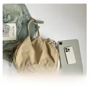 Dettaglio della borsa tote beige con coulisse, doppi spallacci e morbida texture in nylon