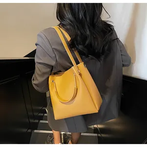 Elegante borsa a secchiello giallo senape mostrata in un contesto di stile con abito
