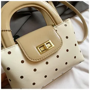 Detailaufnahme der Retro-Handtasche mit Polka-Dots, Metall-Drehverschluss und PU-Ledertextur
