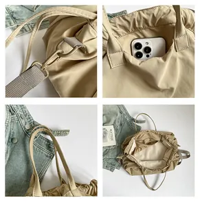 Detail of khaki pleated tote bag showing metal hooks, drawstring design, and spacious interior