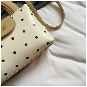 Nahaufnahme der Retro-Punkt-Handtasche mit Ledertextur und goldener Metallschnalle