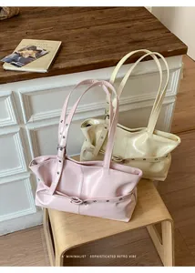 Detail of high-gloss tote bags with decorative buckles on a wooden vintage stool