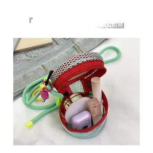 Mini mesh crossbody bag in light green with red zipper showing storage for lipsticks and earbuds