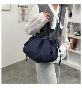 Detail of navy blue pleated tote bag showing drawstring texture and nylon material