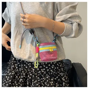 Detail of pink mesh mini crossbody bag featuring neon green rope and long shoulder strap