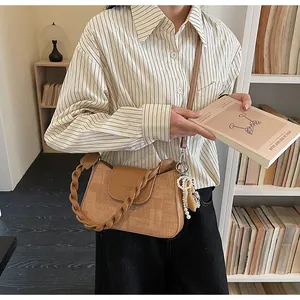 Detail of vintage square crossbody bag with woven handle and elegant pearl charm detail