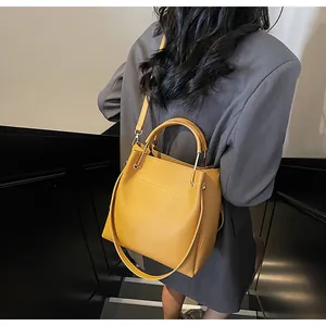 Vista posteriore di una borsa a secchiello giallo senape indossata da una modella