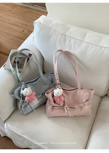 Close-up of minimalist retro tote bags in blue and pink with cute teddy bear pendants