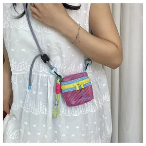 Detail of pink mesh mini crossbody bag with contrast zippers and green rope charm