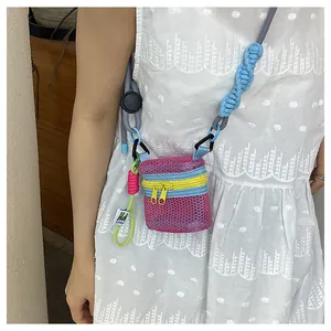 Detailed macro view of pink mesh mini bag with vibrant yellow and blue contrast zippers