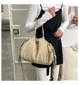 Detail of beige pleated tote bag showing the soft cloud shape and drawstring texture
