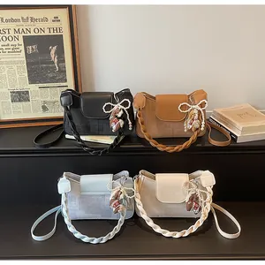 Detail of four vintage-style crossbody bags with pearl bow charms and woven handles