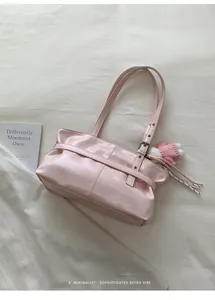 Close-up of light pink tote bag with textured synthetic leather and knit bunny charm