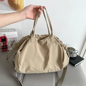 Chic pleated khaki tote bag featuring drawstring closure and adjustable wide strap
