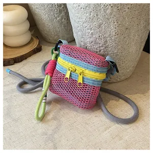 Macro detail of mini mesh bag showing pink mesh texture and yellow double zippers