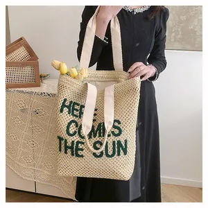 Detail of hand-woven tote bag with Here Comes The Sun embroidery and cream fabric handles