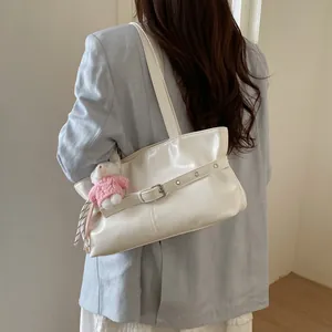 Minimalist white leather tote bag with a cute plush bear pendant on a shoulder strap