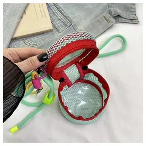 Detail view of mini mesh crossbody bag with red zipper and green lanyard strap