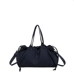 Versatile dark blue pleated drawstring tote bag with adjustable shoulder straps and handle