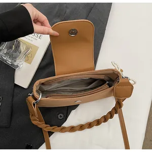 Detail view of the caramel leather bag interior with magnetic snap and pearl strap detail
