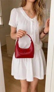 Detail der roten Halbmond-Achseltasche mit plissierter Lacklederstruktur und Reißverschluss
