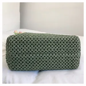 Detail of vintage green woven tote bag showing hollow-out mesh texture and sturdy base