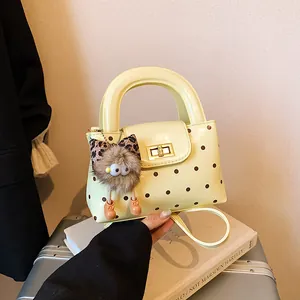 Hellgelbe Polka-Dot Handtasche mit Plüsch-Anhänger und goldenem Metall-Drehverschluss