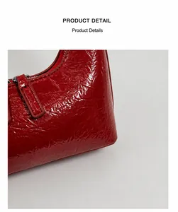Nahaufnahme der roten Lackleder-Textur und des silbernen Reißverschlusses der Tasche
