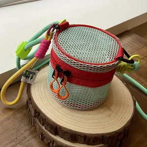 Mini mesh hollow crossbody bag with colorful woven straps and ticket tag in pink and green