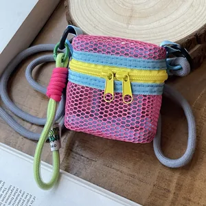 Pink mesh mini crossbody bag with yellow zippers and colorful braided lanyard for daily use